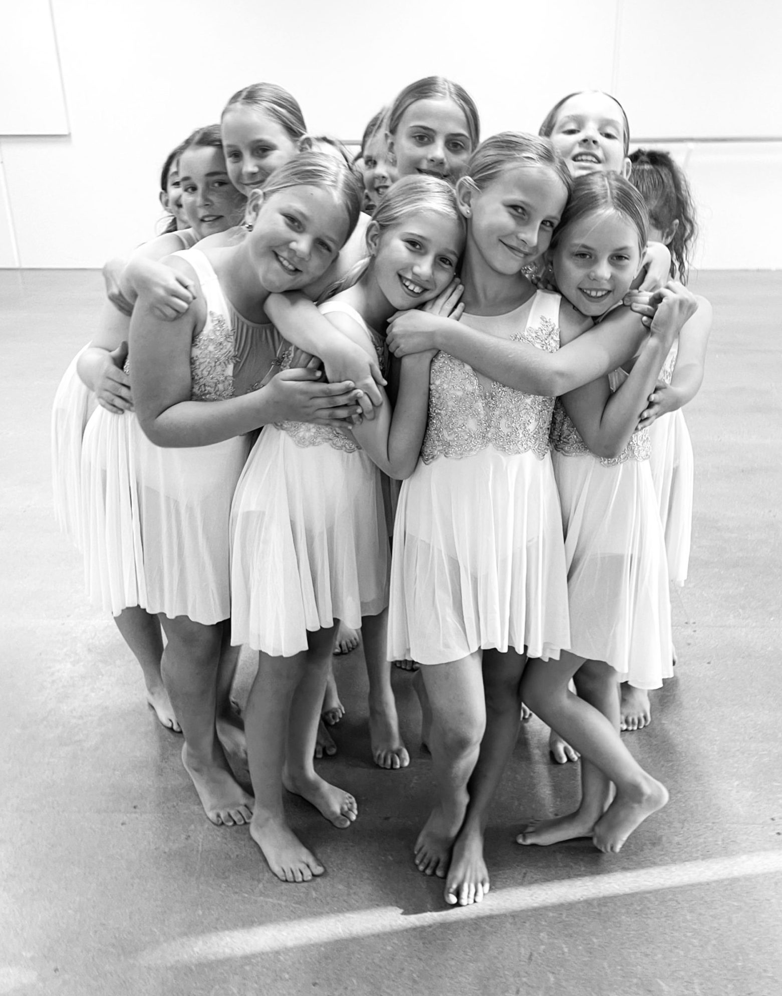 Group of kids in a fun group hug during a dance class at The League Studios in Hervey Bay